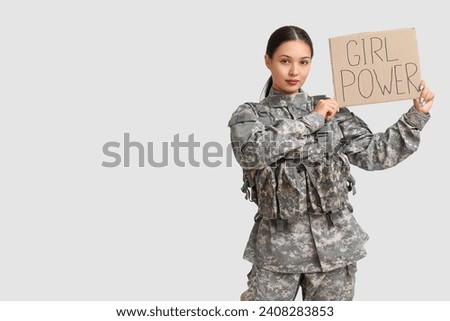 Young female soldier with sign GIRL POWER on white background. Feminism concept