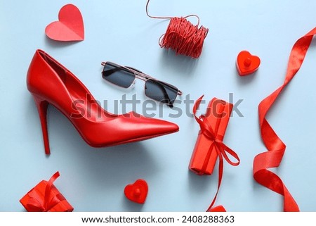 Composition with stylish female shoe, sunglasses and gifts for Valentine's Day celebration on color background Royalty-Free Stock Photo #2408288363