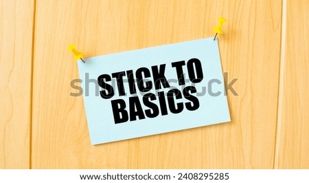 STICK TO BASICS sign written on sticky note pinned on wooden wall