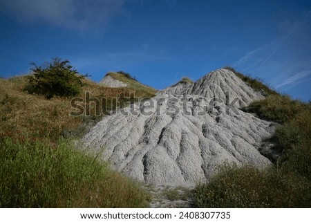 Bare hills of white clay in the Crete Senesi, Tuscany, Italy. A moonscape also called the Accona Desert, between the municipalities of Asciano, Buonconvento and Montalcino. Royalty-Free Stock Photo #2408307735