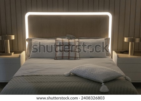 comfortable double bed with decorative lighting above the headboard and night tables on the sides, bedroom Royalty-Free Stock Photo #2408326803