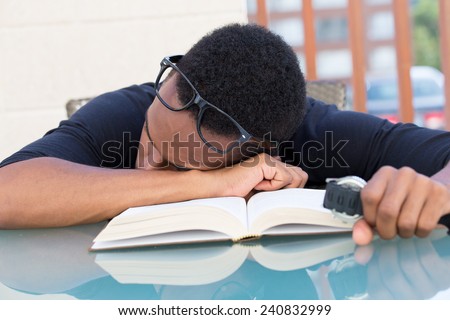 Closeup portrait, nerdy young man in big black glasses holding watch, falling very tired of reading, fast asleep, isolated outdoors outside background. Cramming for all-nighter