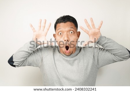 surprised, shocked expression of Asian Man with both fingers open, isolated background