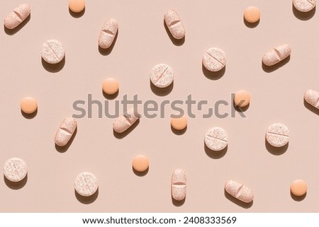 Nature colors pills on a peach fuzz colorl background, top view