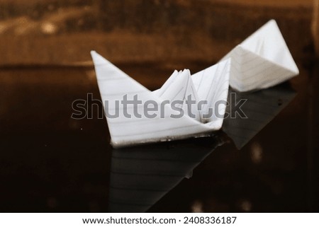 two white paper boats are sailing