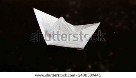 a white paper boat is sailing