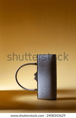 Shiny sparkling silver like woman purse with handle on a yellow background. Creative studio shoot  Royalty-Free Stock Photo #2408343629