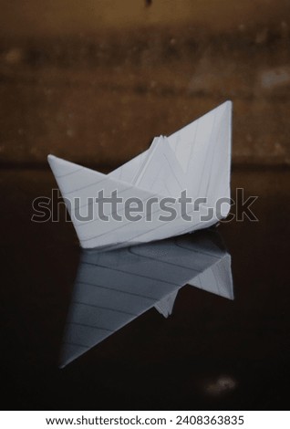 white paper boat with its shadow