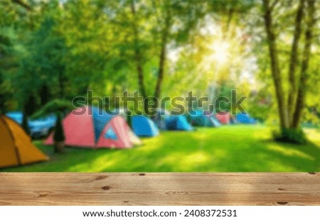Wooden table top on blur tent camping travel tent and grass field.Fresh and Relax concept.For montage product display or design key visual layout.View of copy space.