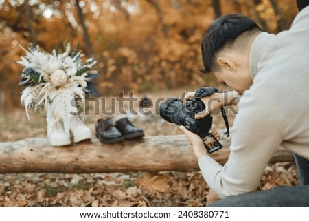 wedding photographer taking pictures of bride and groom shoes, wedding bouquet outdoor.