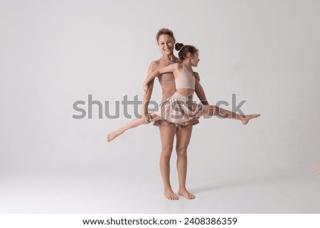 Mother and daughter doing exercise on a white background, two girls do fitness