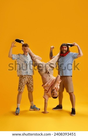 Emotional happy young men, friends in stylish clothes having fun together, relaxing on summer vacation over yellow background. Concept of leisure, vacation, emotions, friendship, fun, bachelor party