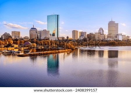 Boston City Skyline over the Charles River in Massachusetts, USA. A tranquil riverscape of Back Bay with golden illuminated wintery foliage in New England.
