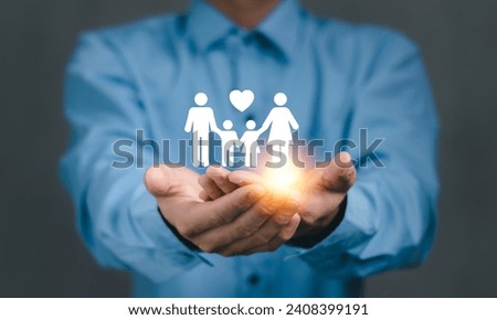 Family insurance and safety concept, Man hand holding family icon with house for protecting and care.
