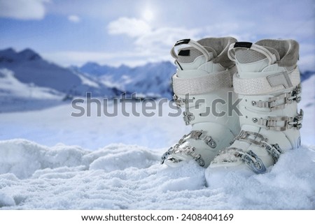 White winter ski shoes in snow and landscape of mountains. 