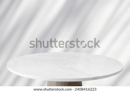 Round marble table top with tree leaves shadow drop on white wall background for mockup product display