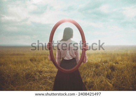 woman holding a mirror who is mirrored appears from behind, identity concept Royalty-Free Stock Photo #2408421497