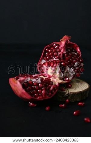 broken pomegranate fruit, scattered pomegranate grains on a black background 
