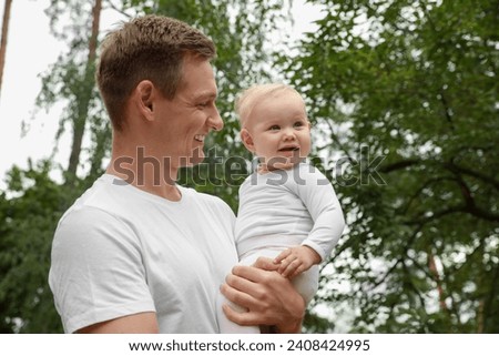 Father with his cute baby spending time together outdoors