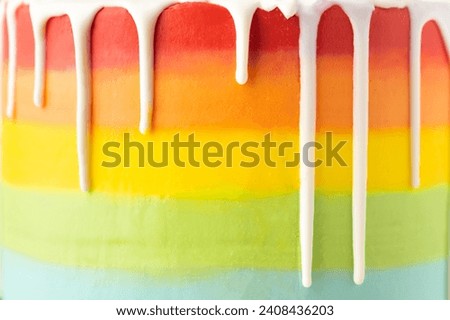 Rainbow cake texture. Close up. Homemade cake with multicolored rainbow chocolate frosting and white chocolate drips. Textured background. Royalty-Free Stock Photo #2408436203