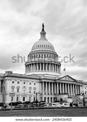 the capitol building in Washington, the picture was taken in December, the background is black and white and there are also cars in the parking lot in the picture