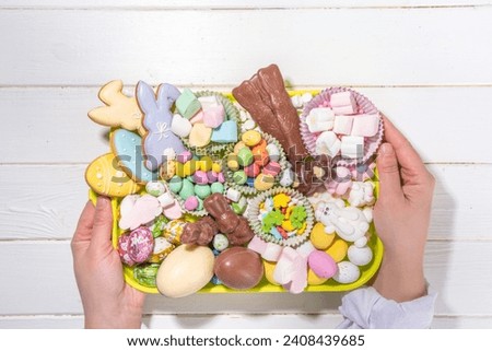 Easter charcuterie board. Sweet Easter party, kids holiday treats assortment - chocolates, easter eggs, marshmallows, candies, chocolate bunny, snacks and treats tray Royalty-Free Stock Photo #2408439685