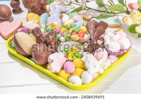 Easter charcuterie board. Sweet Easter party, kids holiday treats assortment - chocolates, easter eggs, marshmallows, candies, chocolate bunny, snacks and treats tray Royalty-Free Stock Photo #2408439691
