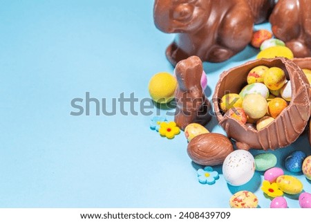 Easter chocolate egg and bunny background. High-colored flat lay with chocolate bunny and rabbits, colorful chocolate eggs. Preparation for Easter, greeting card, Easter sale, top view copy space