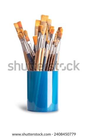 Paintbrushes in a blue plastic cup. Numerous used flat and round paintbrushes of various sizes, used by artists in one stroke painting. The bristles are made of natural and synthetic hairs. Photo. Royalty-Free Stock Photo #2408450779