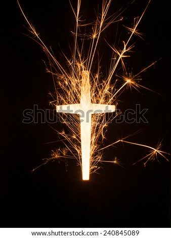 A symbol of glowing sparkling cross on black background.
