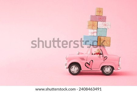 Love composition made of teddy bear and Pink toy car delivery gift boxes on pink background. Minimal concept of Valentine's Day or love. Creative art,minimal aesthetics, writing space and copy space Royalty-Free Stock Photo #2408463491