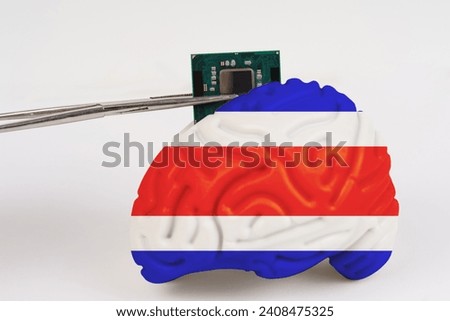On a white background, a model of the brain with a picture of a flag - Costa Rica,a microcircuit, a processor, is implanted into it. Close-up