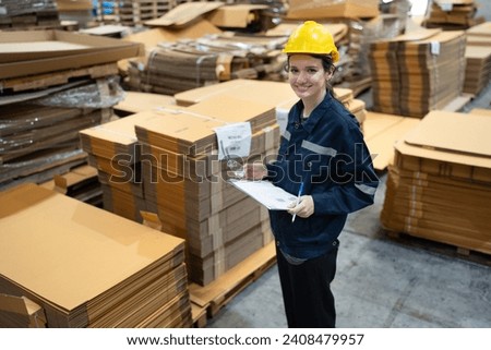 Portrait Caucasian businesswoman use clipboard checking Kraft paper stock in warehouse	
