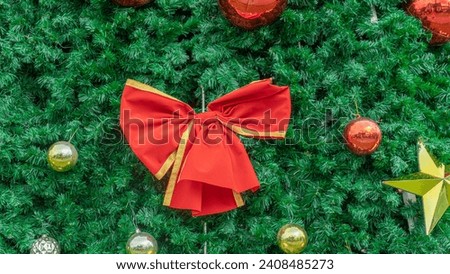 Picture of a giant red bow The bundle on the Christmas tree resembles a large wrapped present. that is ready to give happiness to everyone during the New Year's Eve festival