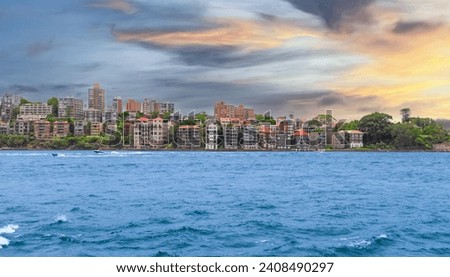 Sydney Harbour viewed from North Sydney with Sydney City Skyline and CBD high-rise, circular quay and Harbour Bridge. Cruise Liner Ship docked on wharf colourful skies NSW Australia