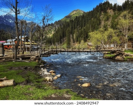 River and hills with wooden house clear sky with few clouds. Picture taken at Taobat kasmir Pakistan