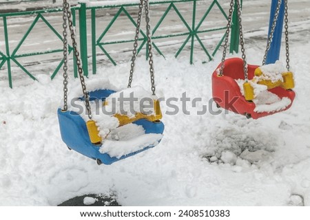 the playground is covered with snow in winter,empty playground in the park in winter