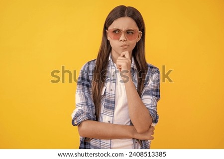 Young pondering teen girl standing in sunglasses. Beautiful teen girl wearing checkered shirt. teen girl with long hair. teen girl in casual style