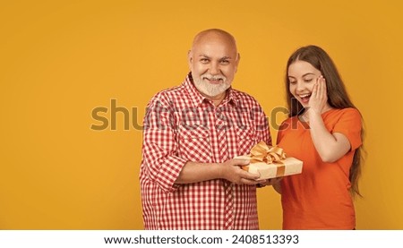 amazed teen girl and grandfather with present box for anniversary