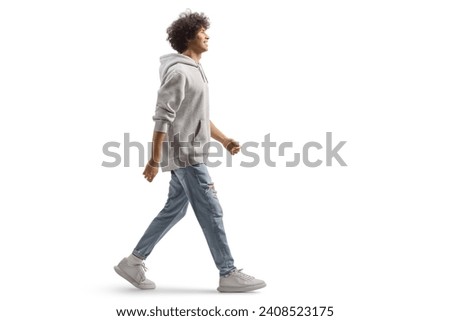 Full length portrait of a tall guy with curly hair walking isolated on white background