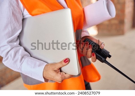 Building inspector using portable two-way radio and computer on site