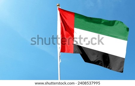 United Arab Emirates flag on cloudy sky. flying in the sky