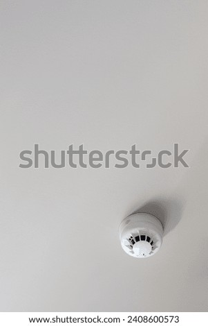 smoke detector mounted on plain ceiling, fire alarm system, copy space