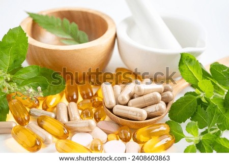 Alternative medicine herbal organic capsule with vitamin E omega 3 fish oil, mineral, drug with herbs leaf natural supplements for healthy good life. Royalty-Free Stock Photo #2408603863