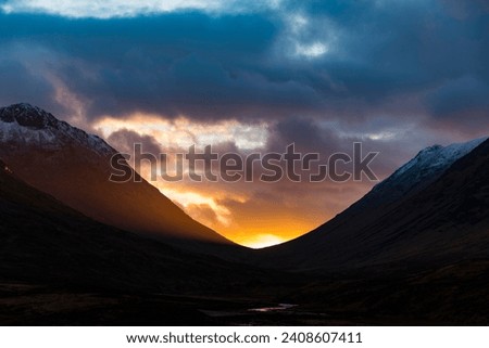 Small stream in the foreground with summit of Stob Coire and Stob Na Doire in the background at sunset, Glen Coe, west Highlands, Scotland, United Kingdom