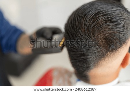 Head of a man with a new look while barber shaving her