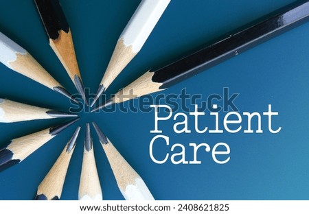 Patient care word text written on a blue board as background with black and white pencils