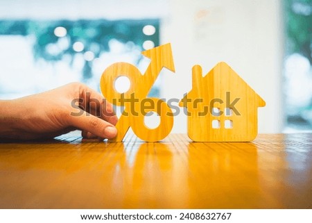 Percentage and house sign symbol icon wooden on wood table. Concepts of home interest, real estate, investing in inflation home loan interest rate hike.