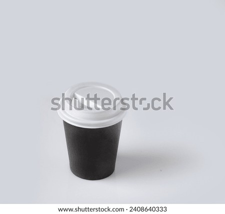 black paper cup for coffee on white glass, space copy, mockup, isolate