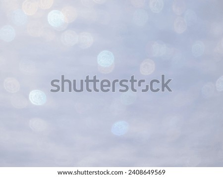 Artistic, shiny, purposely blurred background with white and colorful bokeh effect of snow in sunlight. Photographic bokeh effect